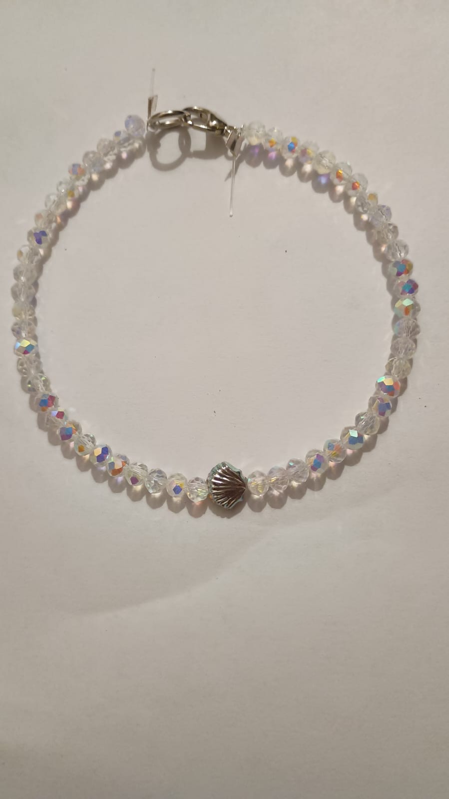 Pulsera de cuentas transparentes tornasoladas con un dije de caracol